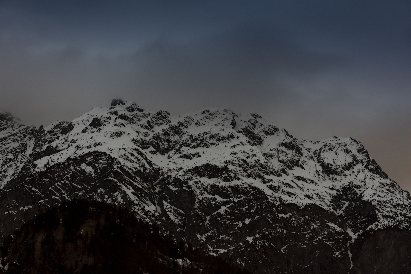 Berggipfel im Morgengrauen mit Schnee bedeckt